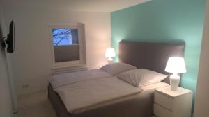 a bedroom with a bed with two lamps and a window at Atelier im Huus Hillig-Geist in Flensburg