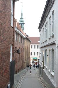 an alley with people walking down a street between buildings at Atelier im Huus Hillig-Geist in Flensburg