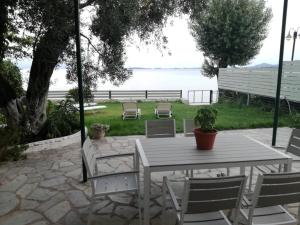 a table and chairs with a view of the water at Stami's Seaside Apartment in Pyrgi