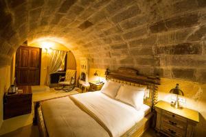 ウチヒサールにあるMaya Caveの石壁のベッドルーム1室(ベッド1台付)