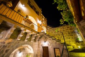 un bâtiment avec un balcon et un escalier la nuit dans l'établissement Maya Cave, à Uçhisar