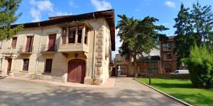 an old building with a brown door on a street at Apartamento ENTREVIÑAS en el corazón de La Rioja in Fuenmayor