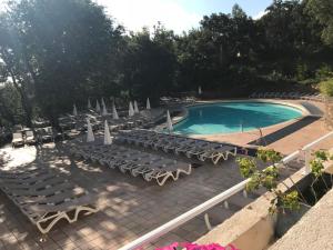a swimming pool with lounge chairs and a swimming pool at LES RESTANQUES DE SAINT-TROPEZ in Grimaud