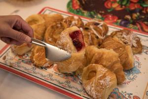 a person holding a spoon over a plate of pastries at Hofsas House Hotel in Carmel