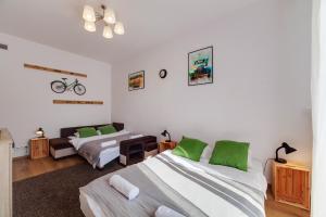 グダニスクにあるDream Loft Rajskaの緑色のアクセントが施された部屋のベッド2台