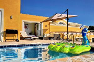 a swimming pool with a pool noodle in front of a house at ARILLAS HILLSIDE VILLA 3 - Provence in Arillas