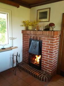 a brick fireplace with a fire in it at Ferienhaus Annelore in Middelhagen