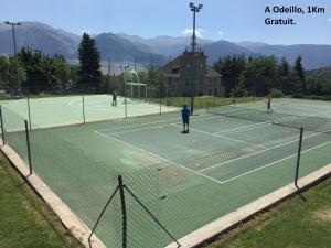 a group of people playing tennis on a tennis court at Nature Appartements Font Romeu in Font-Romeu
