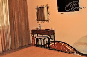 a bedroom with a small table with a mirror at Salute Hotel in Belgorod