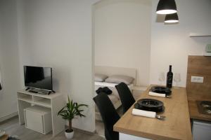 eine Küche mit einem Tisch mit Stühlen und einem TV in der Unterkunft Stylish Apartment in City Center in Pula