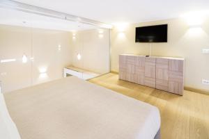 a bedroom with a bed and a flat screen tv at Sanremo Home Loft in Sanremo