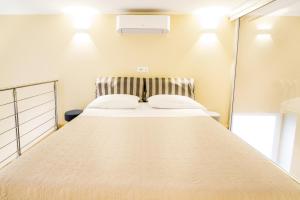 a large bed in a room with a mirror at Sanremo Home Loft in Sanremo