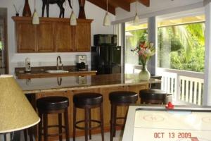a kitchen with a counter and some stools in it at Bamboo Valley Inn in Haiku