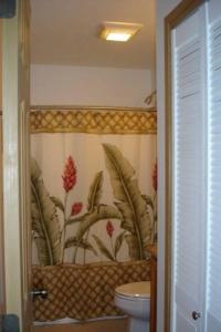 baño con aseo y papel pintado con motivos florales en Bamboo Valley Inn, en Haiku