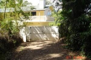 a driveway leading to a house with a fence at Bamboo Valley Inn in Haiku