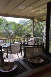 a porch with a table and chairs on a deck at Kailani Suite at hana Kai Resort in Hana