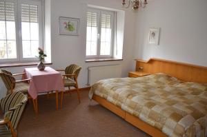 una camera da letto con un letto, un tavolo e delle sedie di Hotel Kinnen a Berdorf
