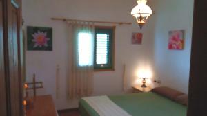 アロナにあるCasa Duermevela Rural WIFI 600 Mbps Energía Solarのベッドルーム(緑のベッド1台、窓付)