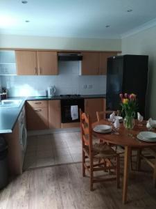 a kitchen with a wooden table and a dining room at 64 Wardo Avenue in London