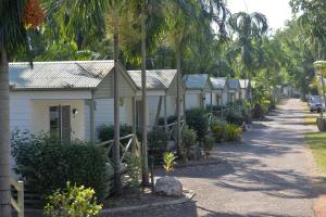 a row of houses on a street with palm trees at BIG4 Howard Springs Holiday Park in Darwin