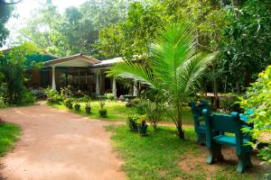 un patio con un banco azul delante de una casa en Sigiri Lodge, en Sigiriya