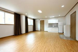 an empty room with a kitchen and a hard wood floor at Traum Hotel & Condo in Gapyeong
