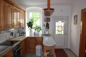eine Küche mit Holzschränken und einem Fenster in der Unterkunft Appartement "Blumengassl" in Mörbisch am See