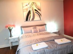 a bedroom with a bed with two towels on it at Gabriel Guesthouse in Rhyl