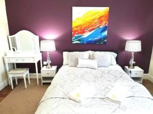 a bedroom with a bed and a painting on the wall at Gabriel Guesthouse in Rhyl