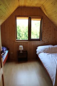 コパリノにあるDomki pod grusząのベッドと窓が備わる小さな客室です。