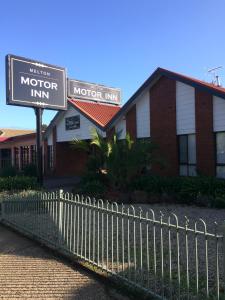 una señal de motociclismo frente a un edificio en Melton Motor Inn and Apartments, en Melton