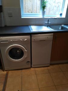 a kitchen with a washing machine and a sink at 64 Wardo Avenue in London