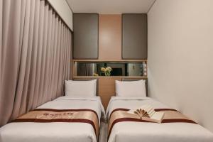 Postel nebo postele na pokoji v ubytování Harmonious Hotel