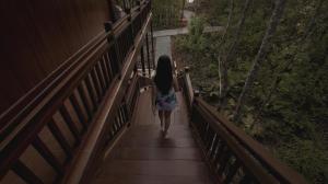 a young girl walking down a wooden bridge at Pratasaba Resort in Maratua Atoll
