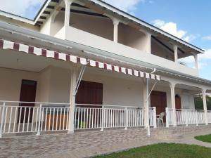 a house with a porch and a balcony at chez jojo in Baie-Mahault