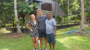 a group of three people standing in a yard at Elegant Hamlets Home Stay in Chilaw