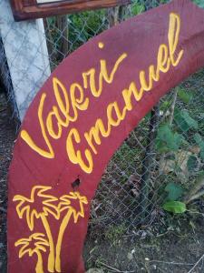 a red sign with yellow writing on top of a fence at Valerie Emanuel Apartments in Bocas del Toro