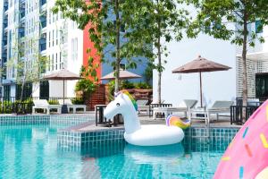 a pool with a unicorn float in a swimming pool at P Plus Hotel in Pattaya Central