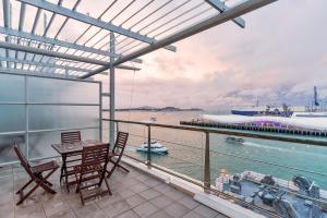 a balcony with a table and chairs and a boat at QV Private Absolute Waterfront Auckland - 263 in Auckland