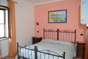 a bedroom with a bed and a painting on the wall at Luna D'Agerola in Agerola