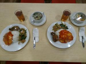 a table with two plates of food on it at Hotel Sampurna Cirebon in Cirebon