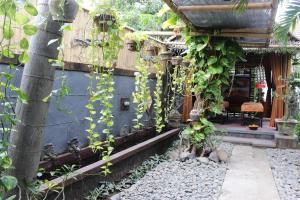 a building with a bunch of vines growing on it at Giri Sari Guest House Pemuteran Bali in Pemuteran