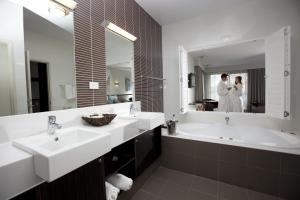 a bathroom with two sinks and a mirror at Macquarie 4 Star in Warners Bay