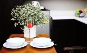 une table avec deux bols et un vase de fleurs dans l'établissement Star 3 Residence, à Rayong