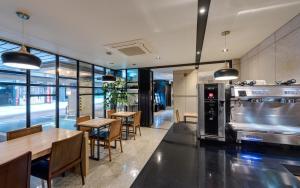 a restaurant with tables and chairs and a large oven at Delight Hotel Jamsil in Seoul