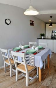 een eetkamer met een witte tafel en stoelen bij Dzuku apartment 40 in Vilnius