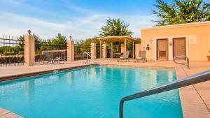 a swimming pool with a patio with chairs at Best Western Plus Kenedy Inn in Kenedy