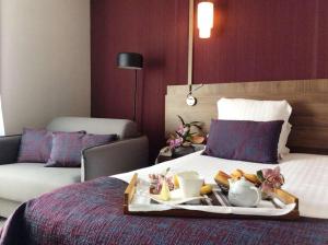 a tray of food on a bed in a hotel room at Best Western Le Duguesclin Hôtel-Restaurant in Saint-Brieuc