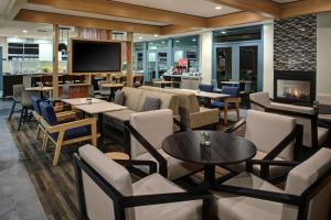 restauracja ze stołami i krzesłami oraz kominkiem w obiekcie Hyatt House Dallas Lincoln Park w mieście Dallas