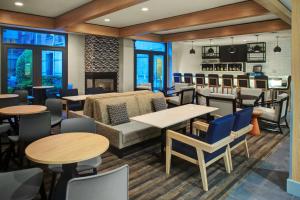 - un restaurant avec des tables, des chaises et un canapé dans l'établissement Hyatt House Dallas Lincoln Park, à Dallas